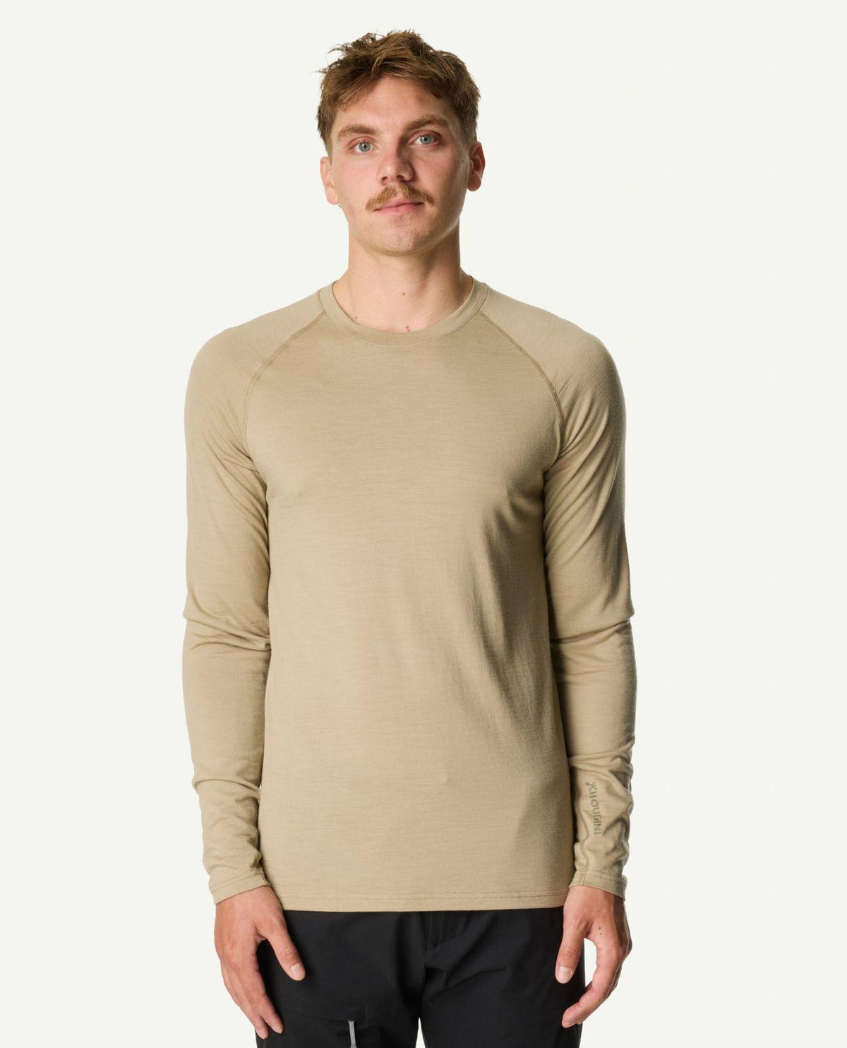 Man bärande Houdini Puremerino Crew underställströja i den gröna färgen powder green.