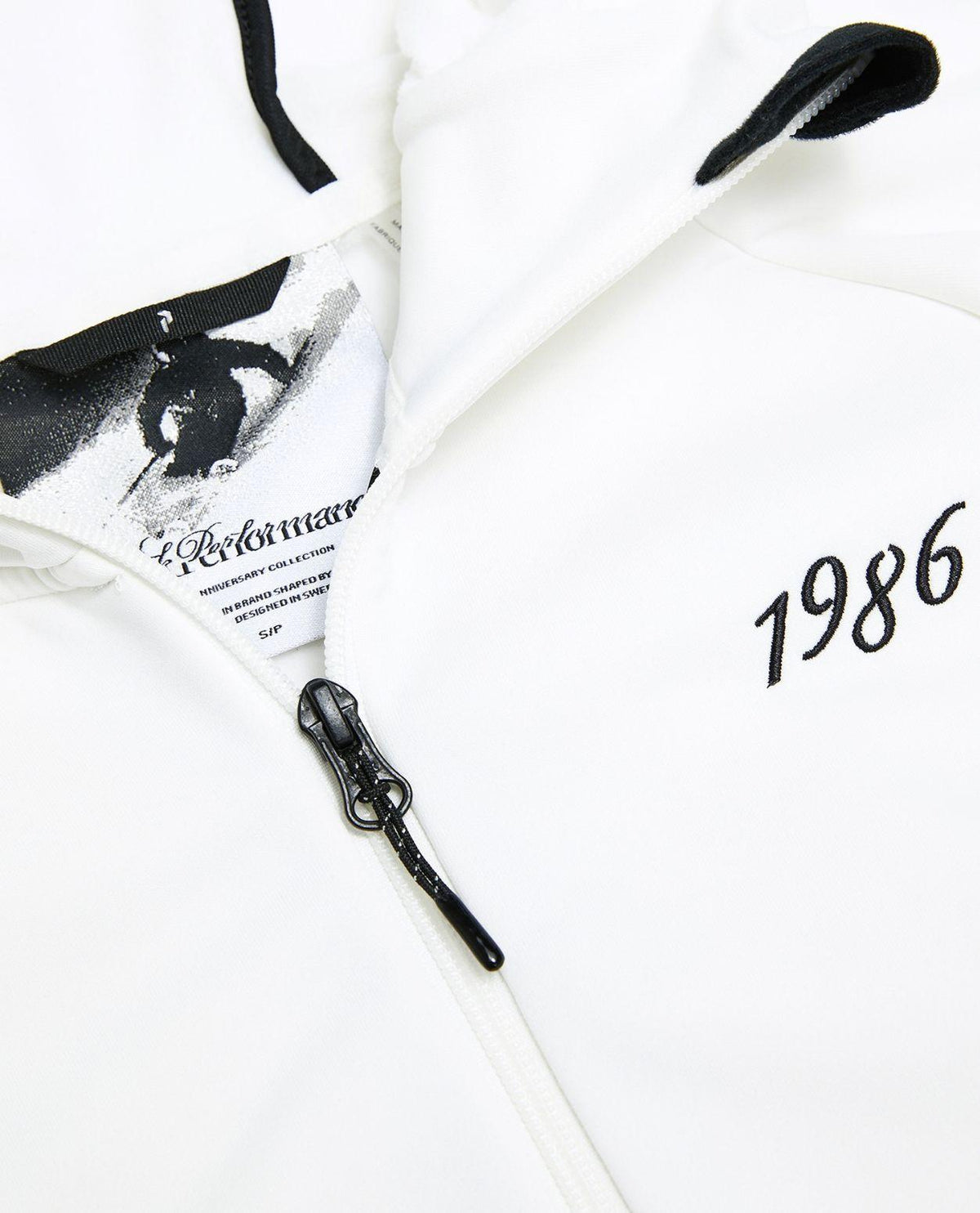 Peak Performance 40Y Rider Zip Hood dam i offwhite, närbild på dragkedja, detaljer och tryck.