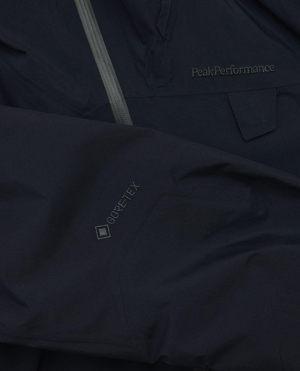 Närbild på Peak Performance Alpine Gore-Tex Insulated Jacket Dam i svart, som visar Gore-Tex-logotypen på ärmen.