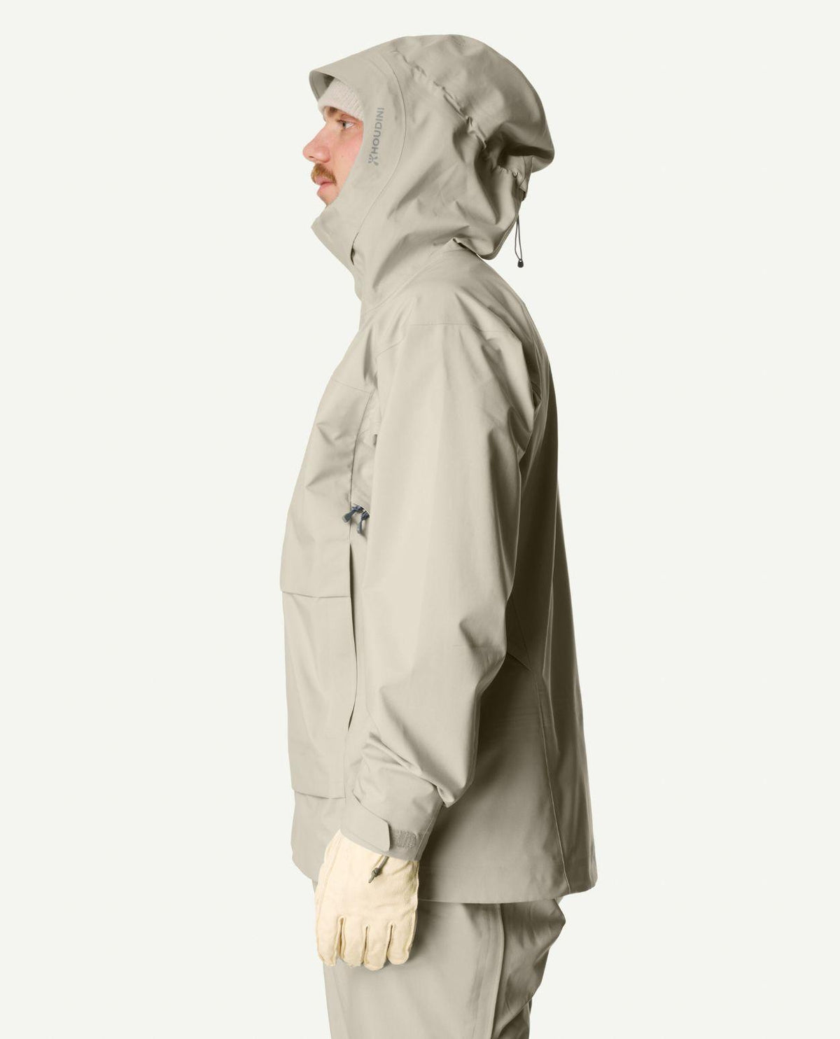 Man i profil som bär Houdini Rollercoaster Jacket II i färgen Greenish Gray.
