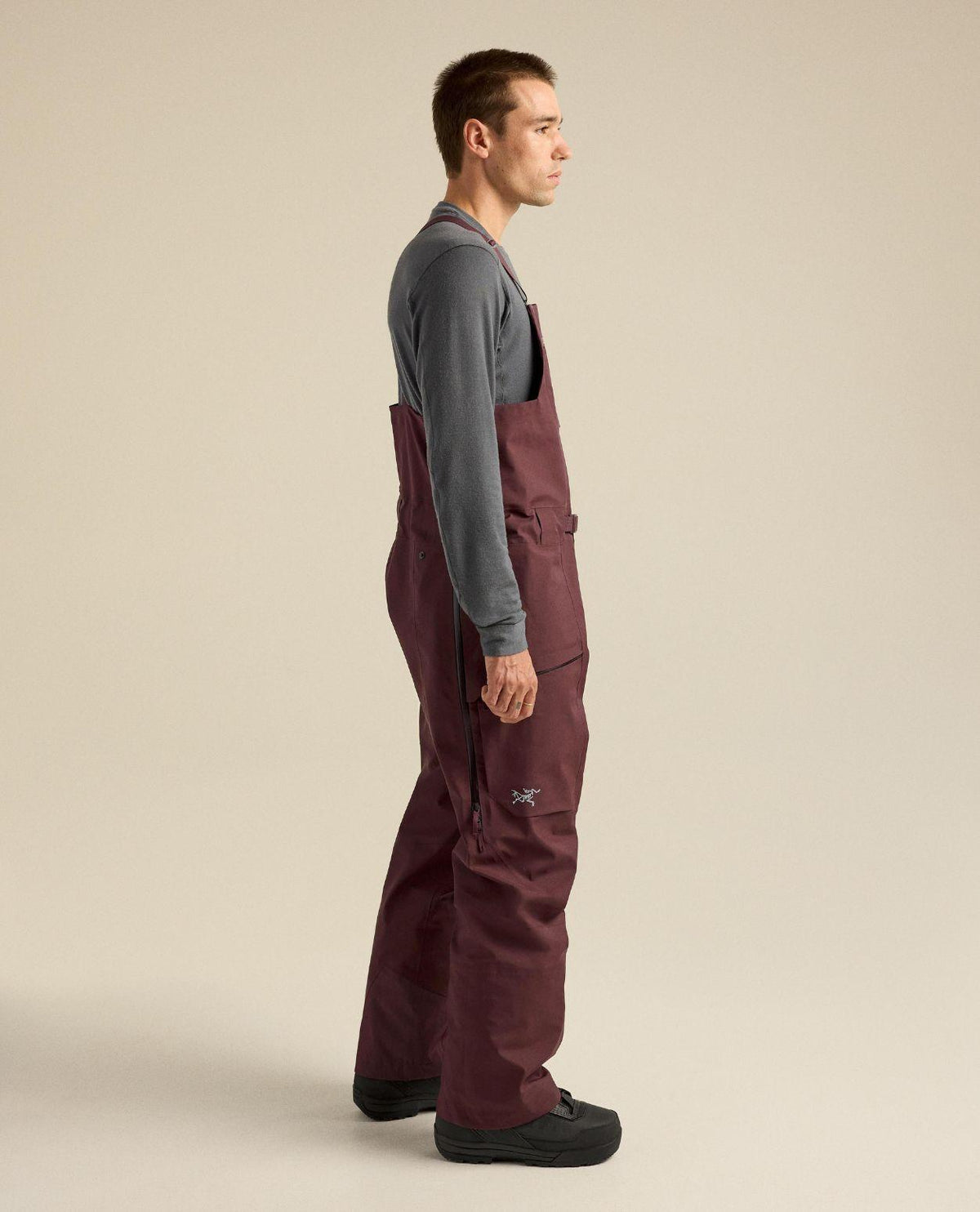 Arc'teryx Sabre Bib Men i lila färg, visad från sidan på modell för skidåkning.