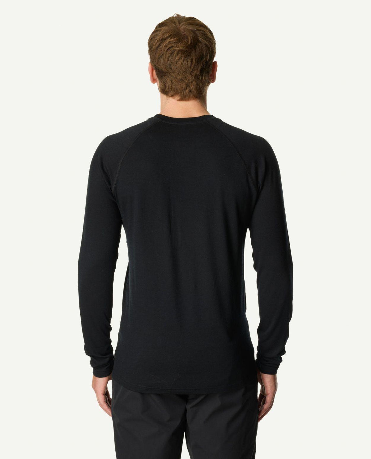 Man i svart Houdini Puremerino Crew underställströja sedd bakifrån.