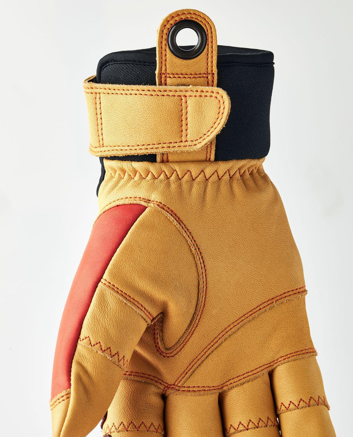 Närbild på handflata och mudd med öljett på Hestra CZone Incline 5 Finger skidhandske i skinn och röd-orange design.