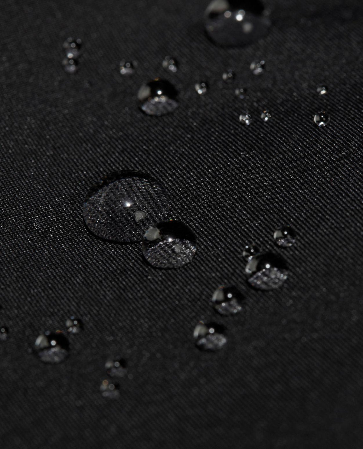 Vattendroppar på det svarta hardshell-materialet till Mammut Haldigrat HS Hooded Jacket