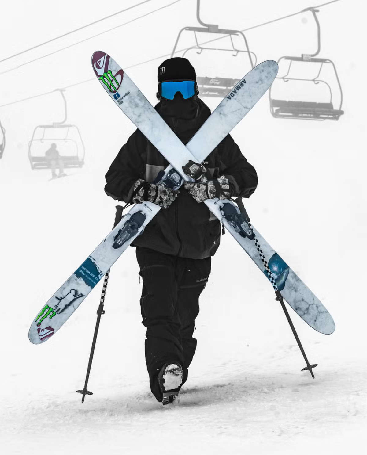 Skidåkare håller upp Armada WHITEWALKER 108 26/27 freerideskidor framför skidlift i snömiljö.