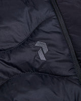 Närbild på Peak Performance Helium Down Shorts i svart med broderad logotyp.