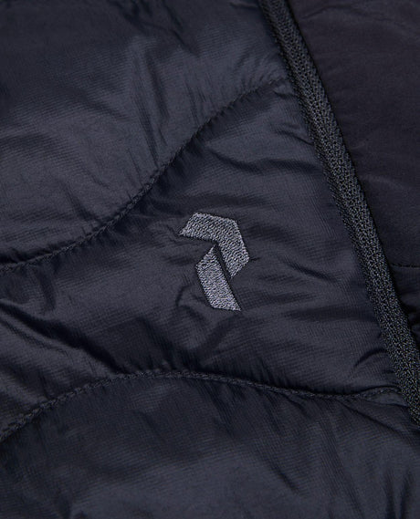 Närbild på Peak Performance Helium Down Shorts i svart med broderad logotyp.