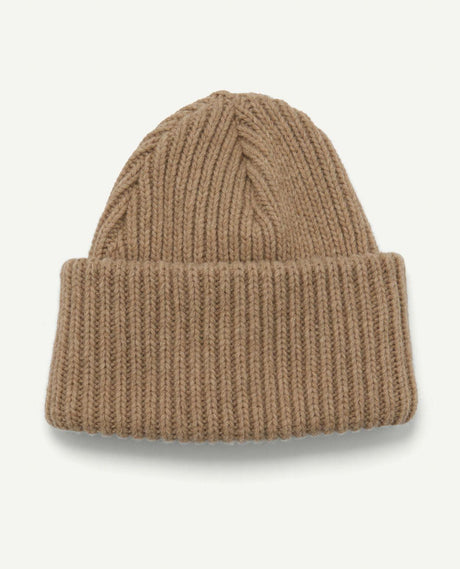Houdini Big Hat i brunt, grovstickat material med en uppvikt kant.