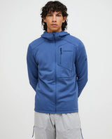 Manlig modell iförd en blå Peak Performance Trail Polartec Zip Hood med huva och bröstficka.