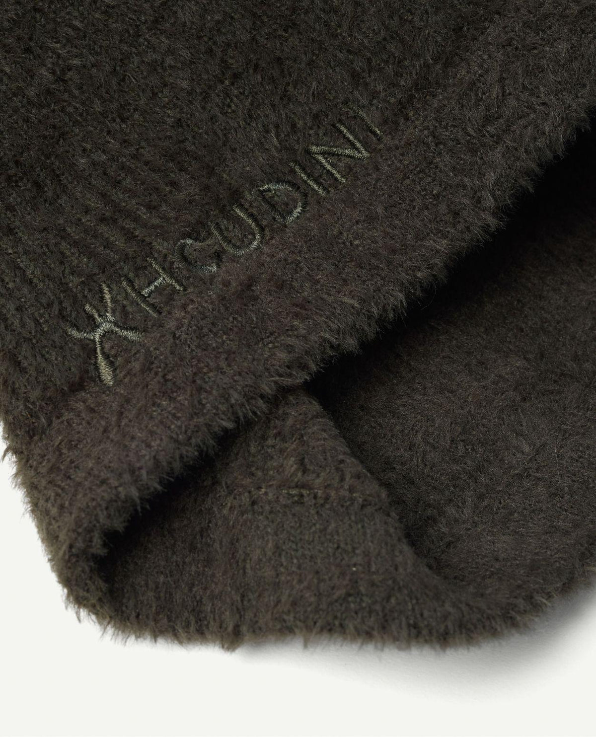 Närbild på grönt Houdini Lykan Neck Gaiter i mjukt fleecematerial med broderad logotyp.