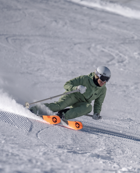 En kvinnlig skidåkare carvar i preparerad backe med Blizzard Black Pearl 88-skidor.