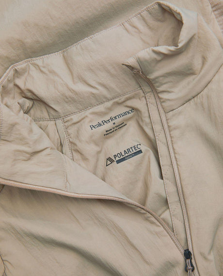 Närbild på insidan och kragen av Peak Performance Freelight Hybrid Liner Men i färgen Avid Beige med Polartec Alpha-detalj.