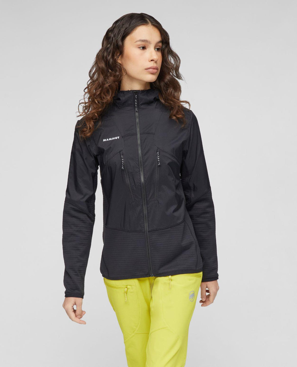 Mammut Aenergy ML Hybrid Hooded Jacket Women i svart färg som bärs av modell mot neutral bakgrund.