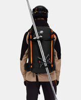 Skidåkare bakifrån som bär en svart Mammut Tour 40 Removable Airbag 3.0 med skidor fästa på utsidan.