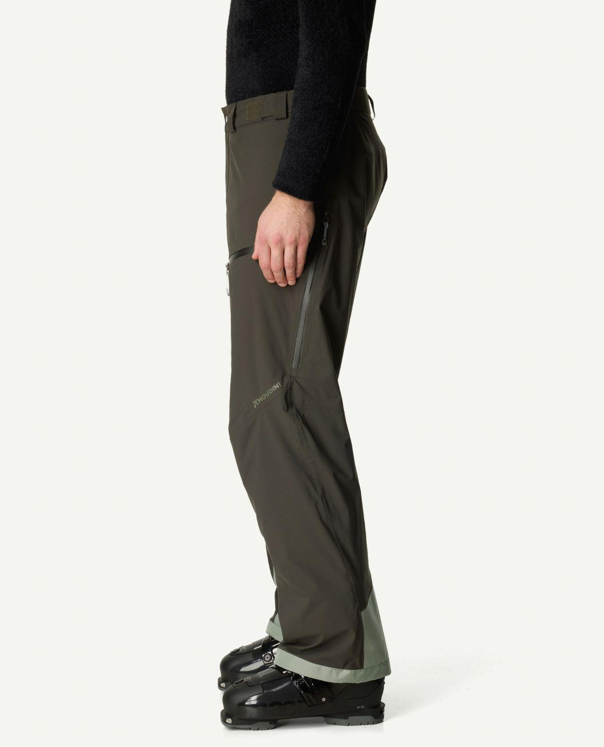 Houdini Ride Insulated Pants Men i färgen Green Illusion, sidovy med skidbyxor och pjäxor.