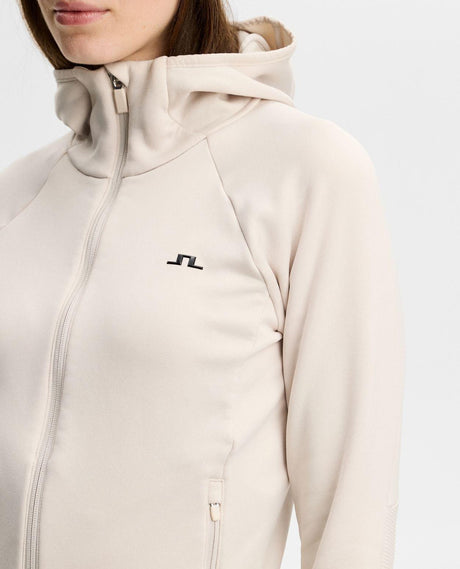 J.Lindeberg Portia Polartec Hood dam i moonbeam beige, närbild på bröstlogga och huva.