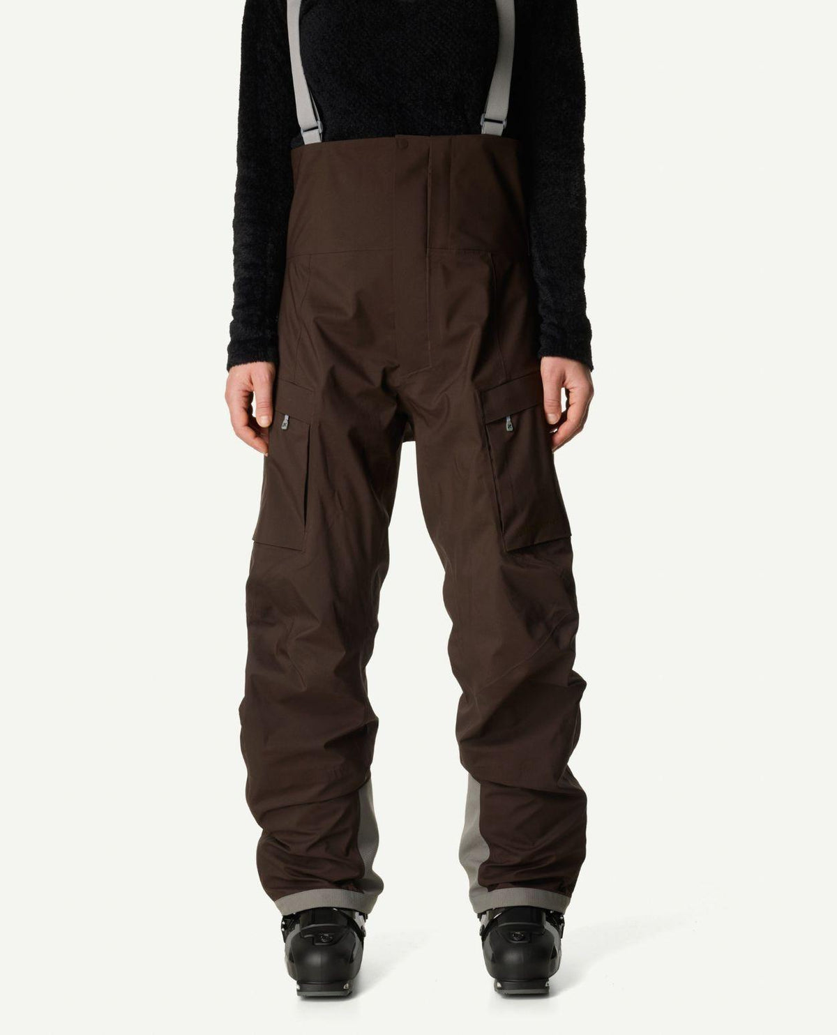 Houdini Rollercoaster Bib Pants dam i brunt med hängslen och cargofickor framifrån.