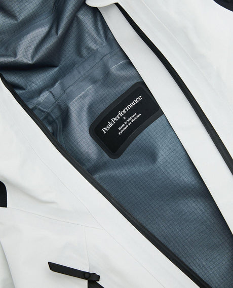 Närbild på insidan och logotypen i Peak Performance Vertical Gore-Tex Pro Jacket dam i vitt.