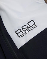 Närbild på broderad R&D-logotyp på Peak Performance skidbyxor i modell Vertical Gore-Tex Pro Bib Pants för herrar.