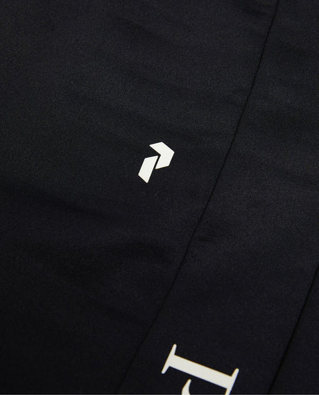 Närbild på Peak Performance Rider Essentials Pants Women i svart med tryckt logotyp.