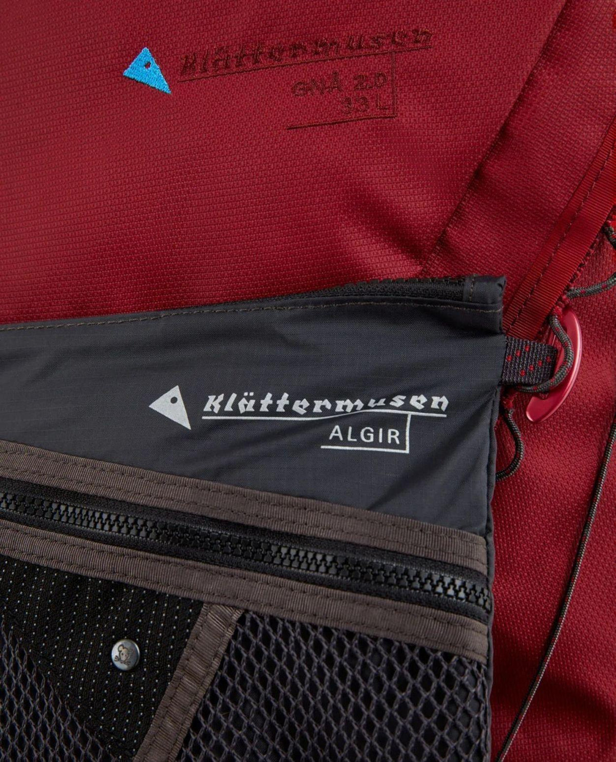Klättermusen Algir Accessory Bag Medium fäst på en röd ryggsäck.