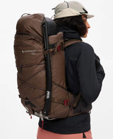 Klättermusen Gyme Backpack 25L i färgen Slate Brown buren på ryggen under en topptur i alpin terräng.