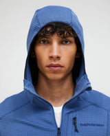 Närbild på en man som bär den blå Peak Performance Trail Polartec Zip Hood-huva.