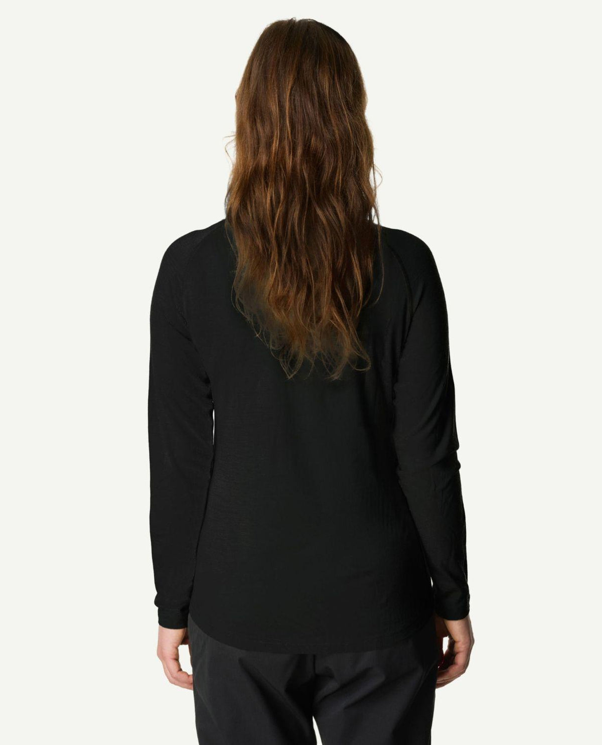 Kvinna sedd bakifrån iklädd Houdini Puremerino Halfzip i svart färg.