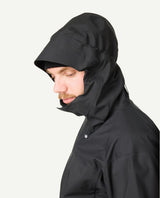 Manlig skidåkare iförd den svarta Houdini Rollercoaster Jacket II med huvan uppdragen.