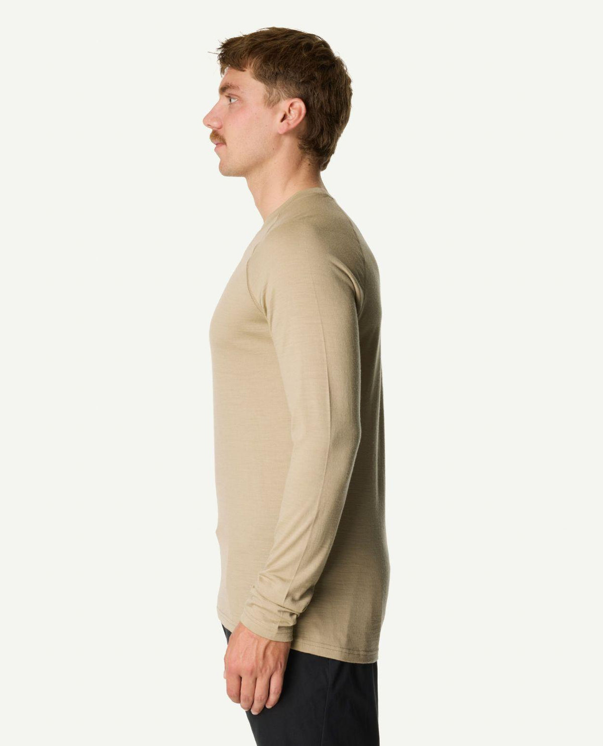 Man i profil som bär Houdini Puremerino Crew Men i färgen powder green från sidan.