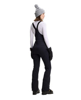 J.Lindeberg Aviana Softshell Bib Pant Women i svart visad bakifrån på skidåkare.