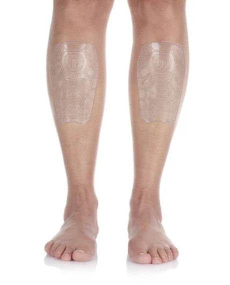 Person visar Sidas Shin Protector EVO på båda smalbenen mot en vit bakgrund.