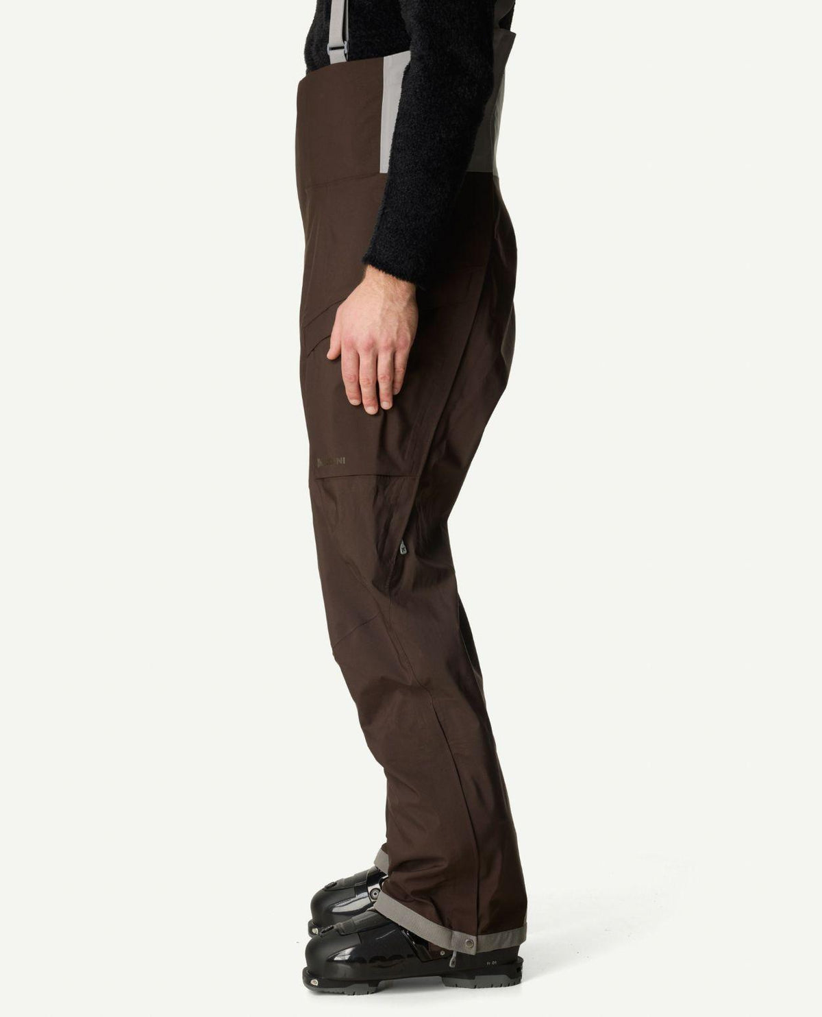 Sidovy på Houdini Rollercoaster Bib Pants II skidbyxor för herr i brunt.