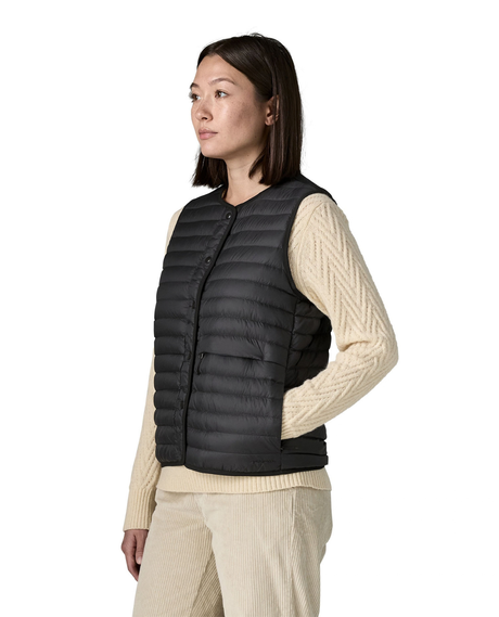 Patagonia LW Reversible Down Sweater Vest Women i svart färg bärs av modell i profil.
