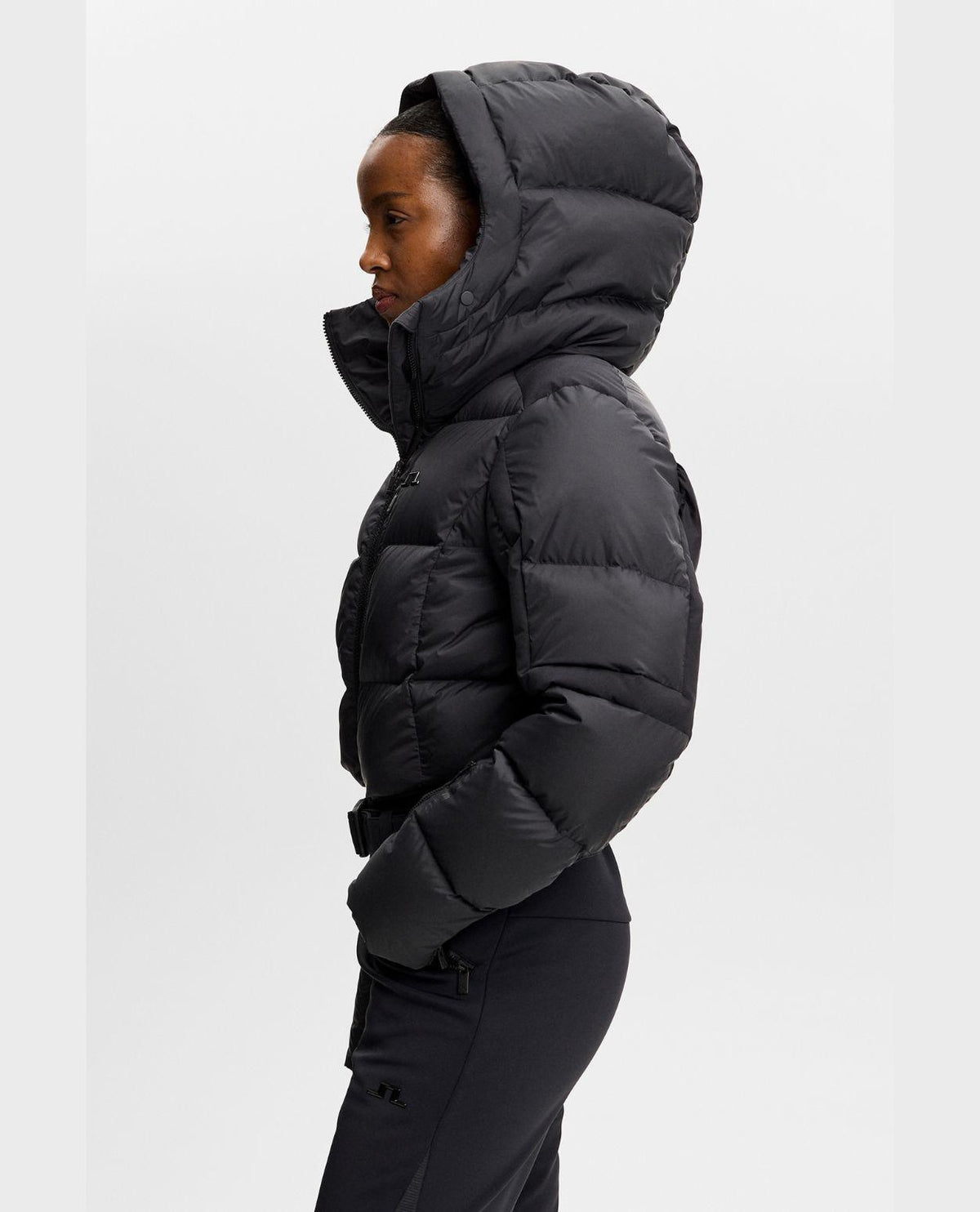 J.Lindeberg Soleil Down One Piece Women - Svart skidoverall i dammodell från sidan med huva