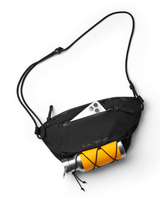 D_b_ Roamer Pro Sling Bag 6L i Amber Teal med telefon och vattenflaska placerade i facken.