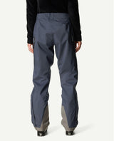 Houdini Ride Pants II dam i blått sett bakifrån buret med skidpjäxor.