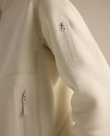 Närbild på ärmficka och detaljer på Arc'teryx Covert 1/2 Zip damtröja i färg Arc Silk Hthr/Salt.