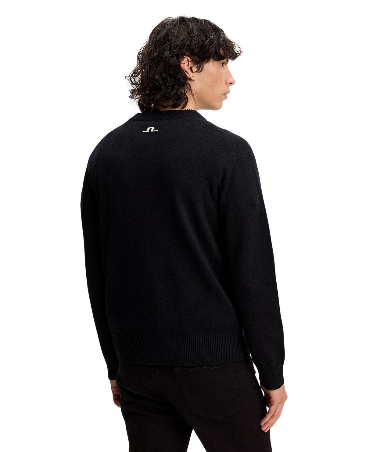 Man i svart J.Lindeberg William Knitted Sweater sett bakifrån mot vit bakgrund.
