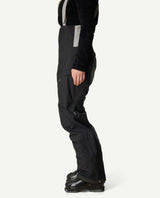 Svart dammodell av Houdini Rollercoaster Bib Pants II från sidan, med hängslen och pjäxor.