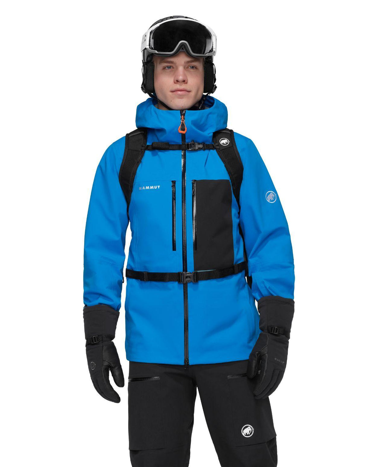 Skidåkare i blå jacka och svart Mammut Nirvana 22 ryggsäck med skidhjälm och skidkläder