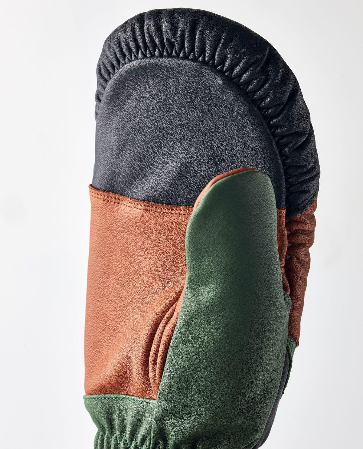 Närbild på Hestra reMix Mitt - Brown/Forest tumhandske i läder som visar materialdetaljer och färgsättning