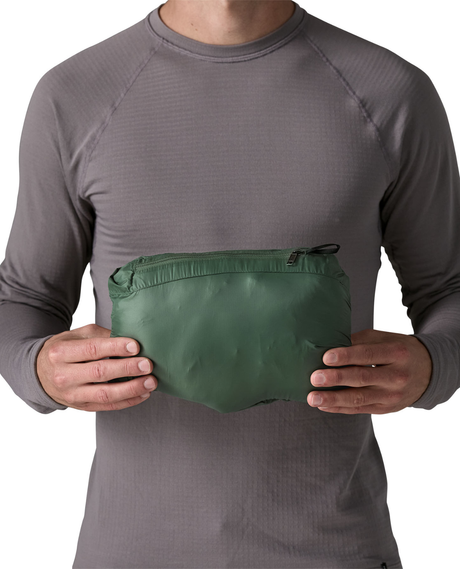 Patagonia Down Sweater Hoody Men i färg Treeline Green hoptryckt i sin egen ficka, visad av modell.