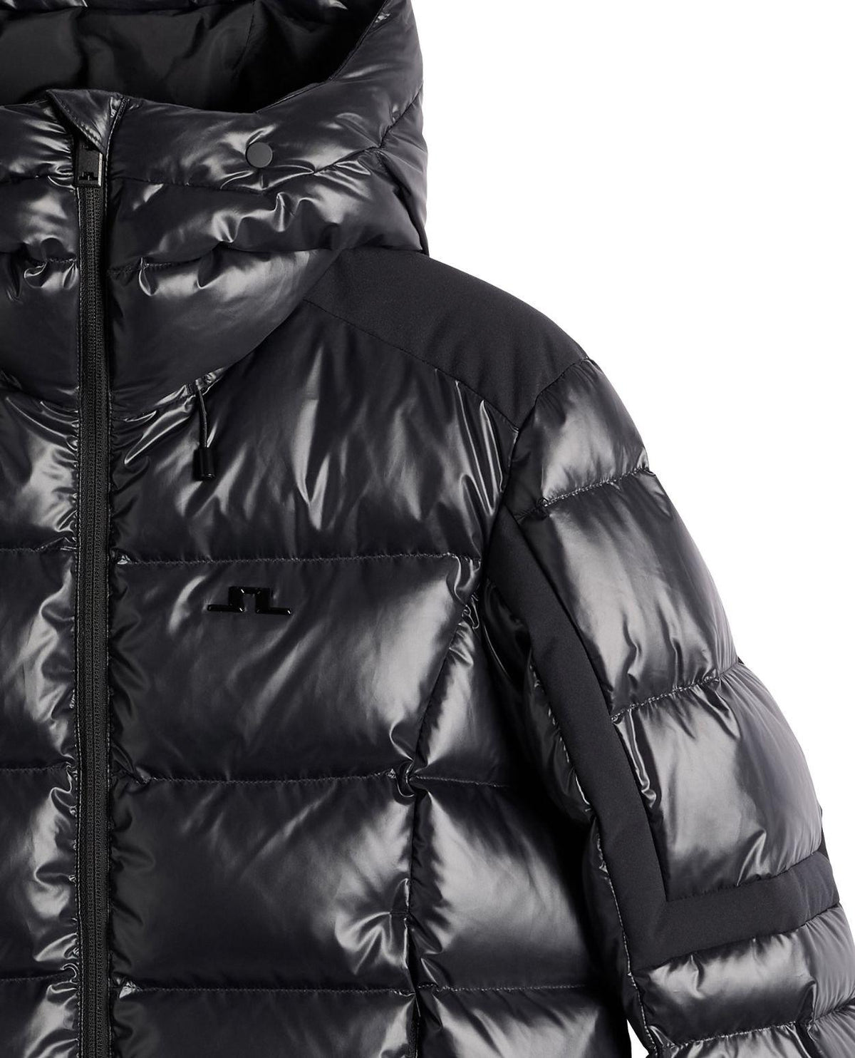 Närbild på J.Lindeberg Nerina Down Jacket för dam i svart, som visar det blanka dunmaterialet, huvan och detaljerna på axeln.