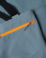 Detaljbild på Mammut Haldigrat HS Bib Pants för herr i färgen strata med orange dragkedja och hängslen.