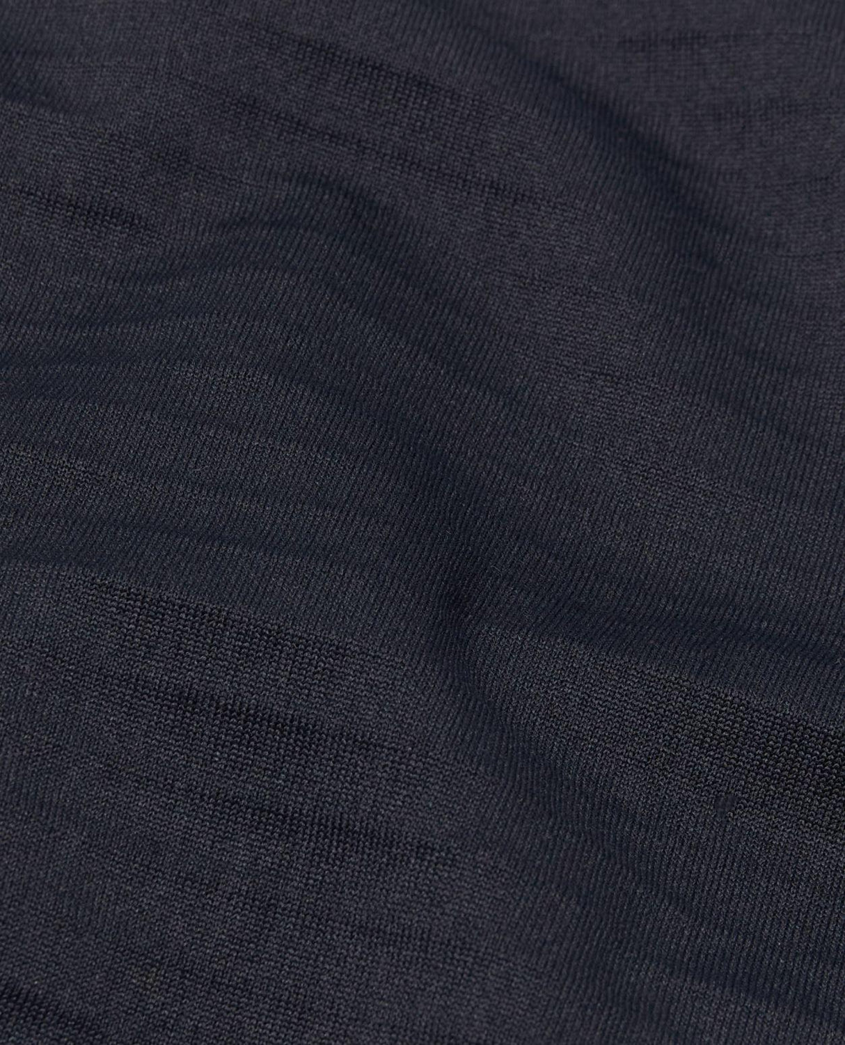Närbild på det svarta funktionsmaterialet hos Mammut Aenergy ML Hybrid Hooded Jacket för herrar. Alpingaraget