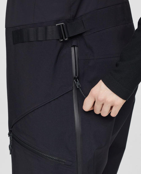 Närbild på dragkedja och detaljer på svarta Mammut Eiger Free Pro HS Bib Pants dam.