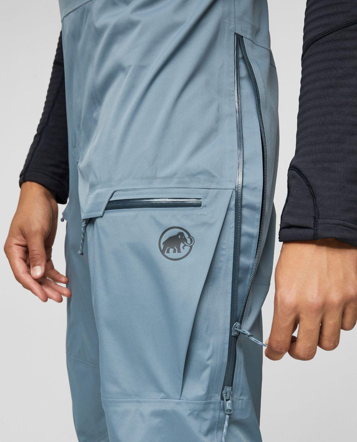 Mammut Haldigrat HS Bib Pants Men i strl 50 i färgen Strata visar fickdetaljer och ventilationsdragkedja.