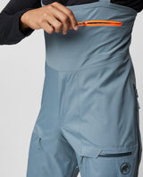 Mammut Haldigrat HS Bib Pants Men - Strata hängselbyxor i grått med orange dragkedja på bröstfickan.