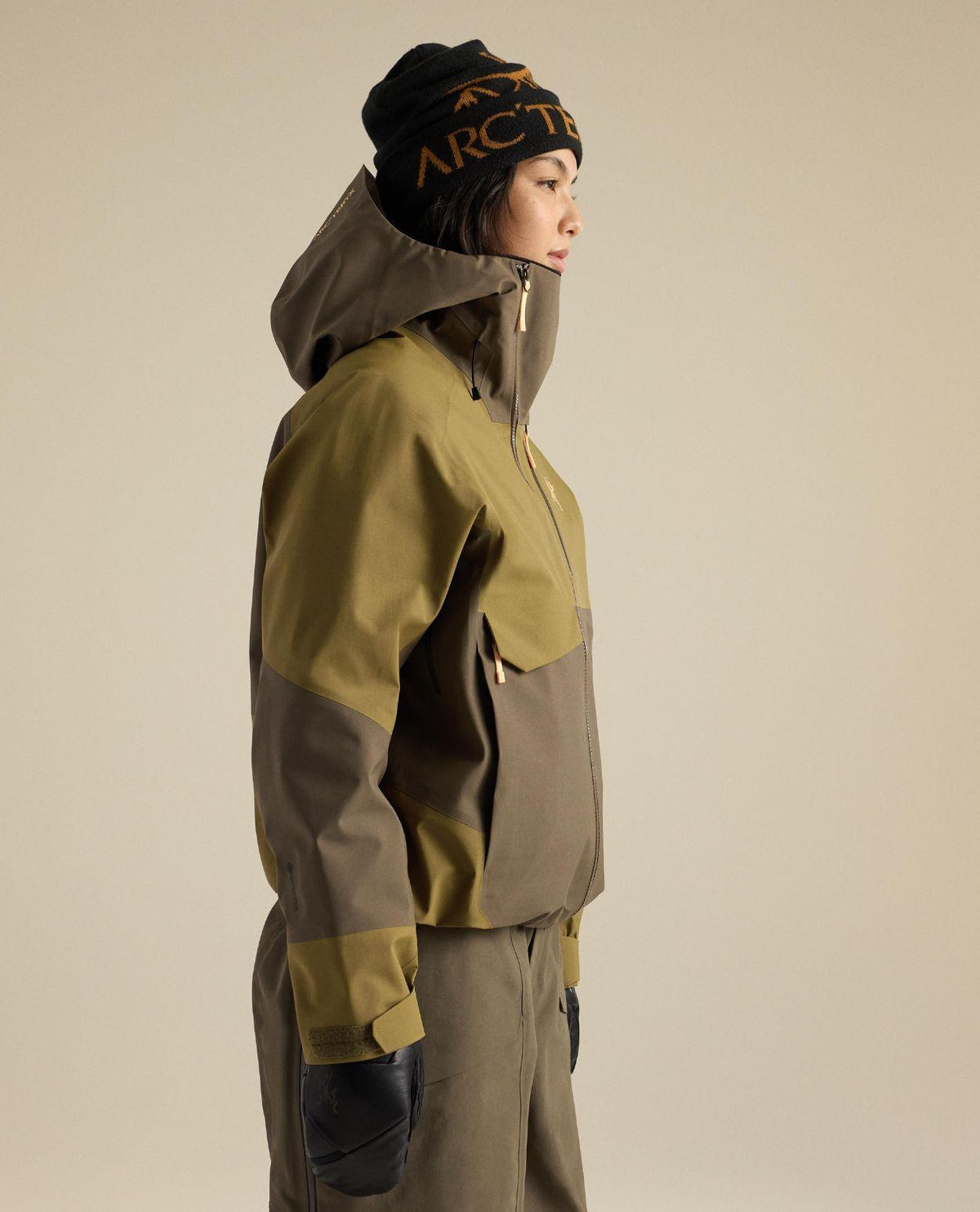 Kvinna i profil som bär den bruna skidjackan Arc'teryx Sidewinder Jacket med GORE-TEX Pro-material.